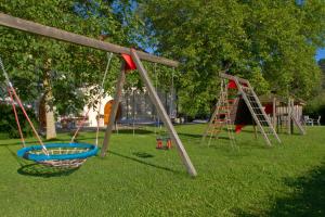 un parque infantil con 2 columpios y un tobogán en Bauernhofpension Herzog zu Laah, en Linz