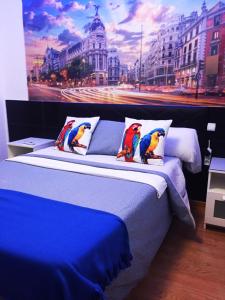 a bedroom with a blue bed with a painting on the wall at Chueca Gran Via Apartaments TPH in Madrid