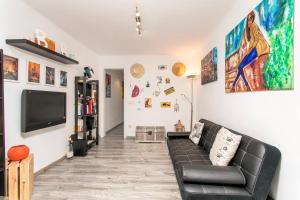 a living room with a couch and a tv at Apartamento BaBa in Hospitalet de Llobregat