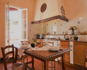 ドルチェードにあるCasa del mulino 2のテーブル、椅子、テーブル席付きのキッチンが備わります。