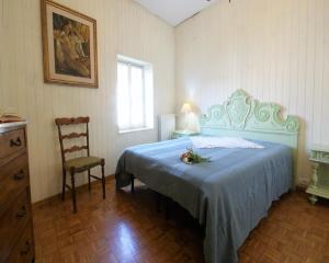 ドルチェードにあるCasa del mulino 3のベッドルーム1室(青い毛布と椅子付きのベッド1台付)