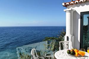 un tavolo con un cesto di frutta in cima all'oceano di OurMadeira - Cottage do Mar, secluded ad Arco da Calheta