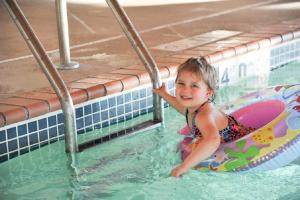 a little girl in a raft in a swimming pool at River Valley Inn & Suites in Osceola