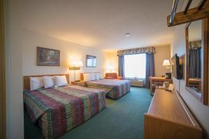 a hotel room with two beds and a television at River Valley Inn & Suites in Osceola