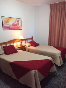 a hotel room with two beds with red pillows at Apartamentos Jucar in Frontera