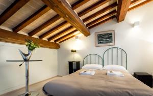 een slaapkamer met 2 bedden en houten plafonds bij Guesthouse Via Di Gracciano - Adults Only in Montepulciano