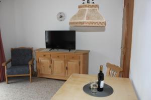 a table with a bottle of wine on top of a television at Fewo Königsberger in Garmisch-Partenkirchen
