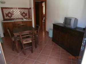 cocina con mesa de comedor y TV en Casa Gallo, en Cala Gonone