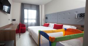 a bedroom with a bed with a toy crib at Hotel K10 in Urnieta