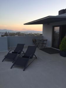 two lounge chairs on the roof of a house at Stylish Seaview Rooftop in Thessaloniki