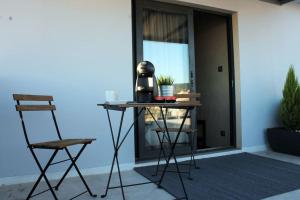 a table and two chairs in front of a door at Stylish Seaview Rooftop in Thessaloniki