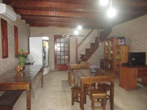 uma cozinha com mesas de madeira e uma escada num quarto em Pousada Punta Cana em Estância Teixeira