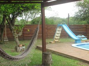 a hammock with a slide next to a pool at Pousada Punta Cana in Estância Teixeira