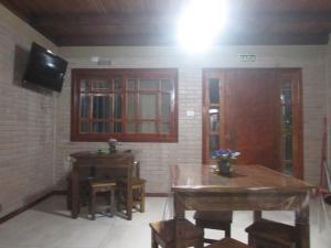a room with two wooden tables and a television at Pousada Punta Cana in Estância Teixeira