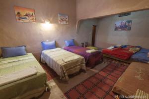 a room with three beds in a room at Kasbah Ounila in Aït Ben Haddou