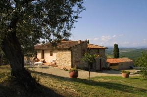a small stone house with a tree in front of it at Agriturismo I Ceppi in San Casciano in Val di Pesa