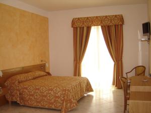 a hotel room with a bed and a window at Hotel Residence Charly in Lido di Fermo