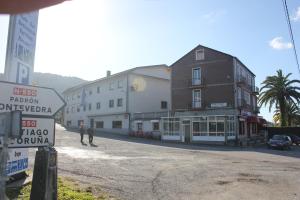 two men walking down a street next to buildings at P Residencia PIVIDAL in Picaraña +42 photos