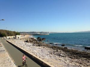 a woman riding a bike on the beach at Beautiful Private Room next to Lisbon - NEW in Paço de Arcos