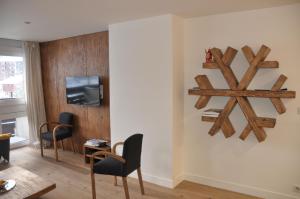 a living room with wooden walls and chairs and a tv at Les Cîmes - Cosy apartment in Val-d'Isère