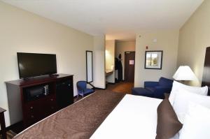 ein Hotelzimmer mit einem Bett und einem Flachbild-TV in der Unterkunft Cornerstone Inn & Suites Oelwein in Oelwein