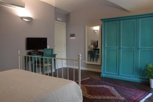 a bedroom with a blue cabinet and a television at Residenza Cavour in Acireale