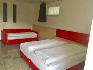 two beds in a room with red and white at Casa Lampone in Trento