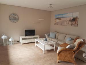 a living room with a couch and a tv at Ferienwohnung Nordseetraum in Hage