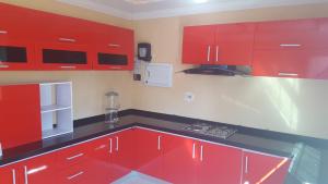 a kitchen with red cabinets and black counter tops at Mathlyn Guest House in Francistown