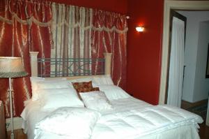 a bedroom with a white bed with a red wall at Sommerville Court Motel Bed & Breakfast in Lucknow