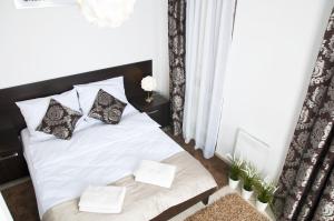 a bedroom with a bed with white sheets and pillows at Apartament IKAR blisko morza in Rewal