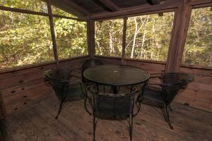 una mesa y sillas en el porche de una cabaña en Lake Barkley State Resort Park, en Cadiz