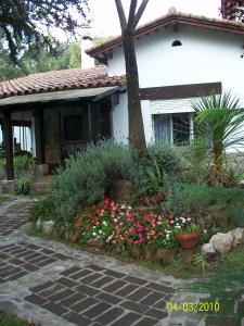 uma casa com um jardim de flores em frente em Familia Luchetti em La Falda