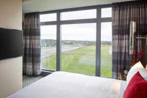 a bedroom with a large window looking out at an airport at Kimpton Overland Hotel - Atlanta Airport, an IHG Hotel in Atlanta