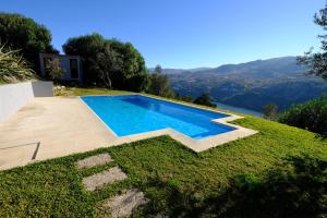 uma piscina ao lado de uma casa em Casas do Casinhoto - Casa com Vista Douro em Baião
