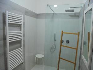 prysznic ze szklanymi drzwiami i stołek w łazience w obiekcie Travel and Living w mieście Trani +37 zdjęć