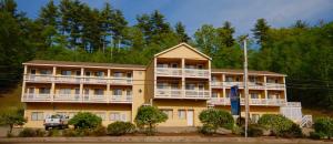 a large yellow building with white balconies at NASWA Resort in Laconia