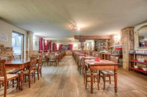 una sala da pranzo con tavoli e sedie in legno di Hotel Meublé Mon Rêve a Breuil-Cervinia