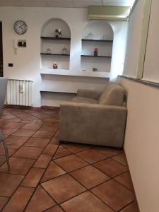 a living room with a couch sitting on a tile floor at Luxurious Street Apartments in Catania
