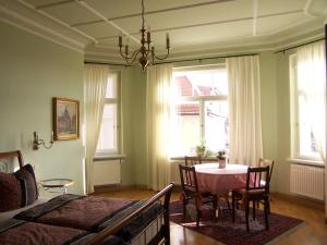 a bedroom with a table and chairs and a bed at Hotel-Appartement-Villa Ulenburg in Dresden