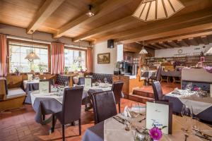 - un restaurant avec des tables et des chaises dans une salle dans l'établissement Hotel Enzian, à Pertisau