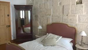 un letto in una camera da letto con parete in pietra di Le Lapin Blanc a Saint-Rémy-de-Provence