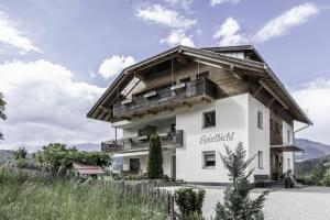 een groot wit gebouw met een houten dak bij Haus Spielbichl in San Lorenzo di Sebato
