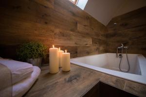 two candles are sitting next to a bath tub with candles at Domek nad Potokiem in Nowy Targ +76 photos