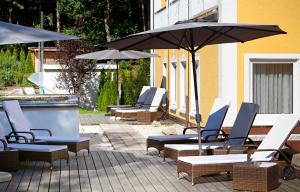 a group of chairs and umbrellas next to a pool at Vitalhotel Sonneck in Bad Wörishofen