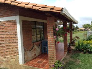 un edificio de ladrillo con pérgola y patio en Villa Liliana Lodge Mesa de los Santos, en Los Santos