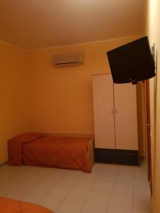 ein Schlafzimmer mit Bett und Flachbildfernseher in der Unterkunft Hotel Mariagrazia in Calopezzati