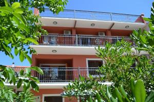 an apartment building with balconies and trees at Villa Agava in Vrboska