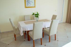 a dining room table with white chairs and a vase on it at Villa Edelweiss in Sveti Stefan