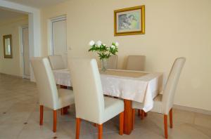 a dining room table with chairs and a vase of flowers at Villa Edelweiss in Sveti Stefan